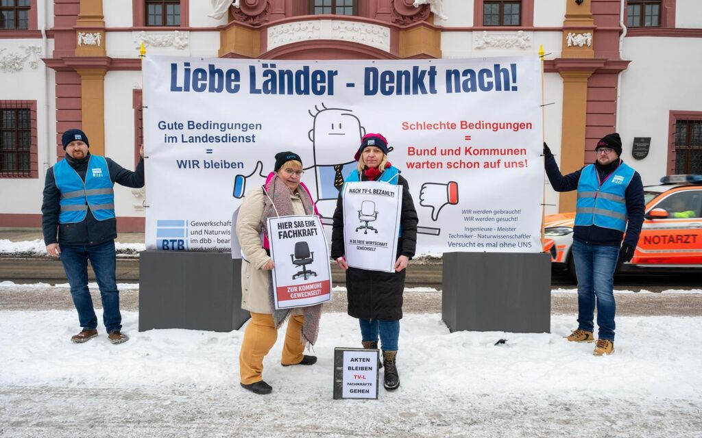Mitglieder in Erfurt vor großem Plakat im Schnee