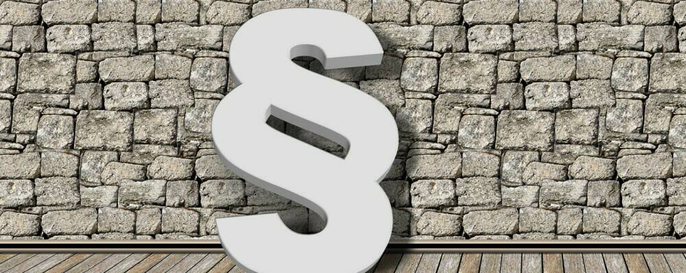 Paragraphen-Symbol vor einer Mauer